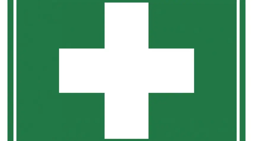 First aid sign with white cross on green background